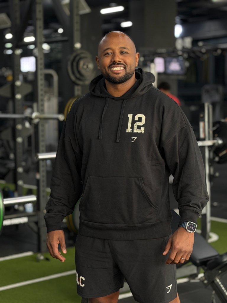 Homme portant un hoodie Gymshark dans une salle de sport moderne