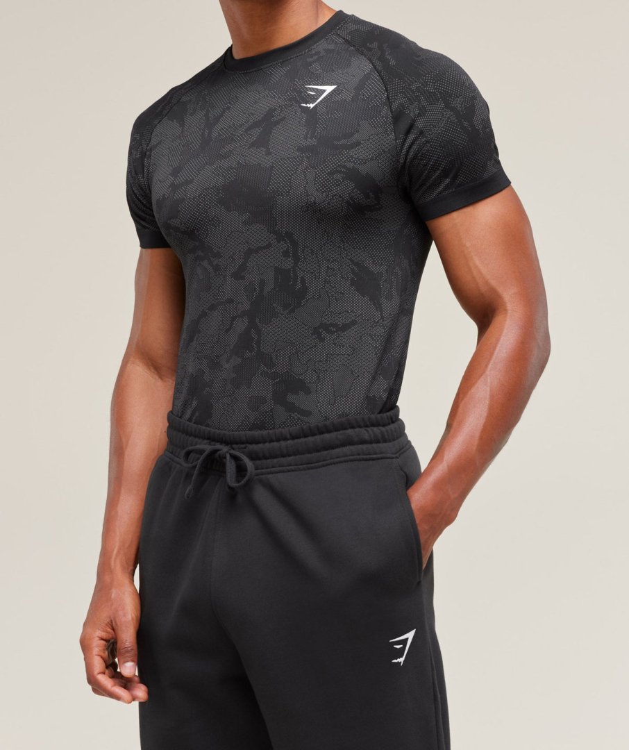 Homme portant le Gymshark Geo Seamless T-Shirt noir camo, vue de trois quarts