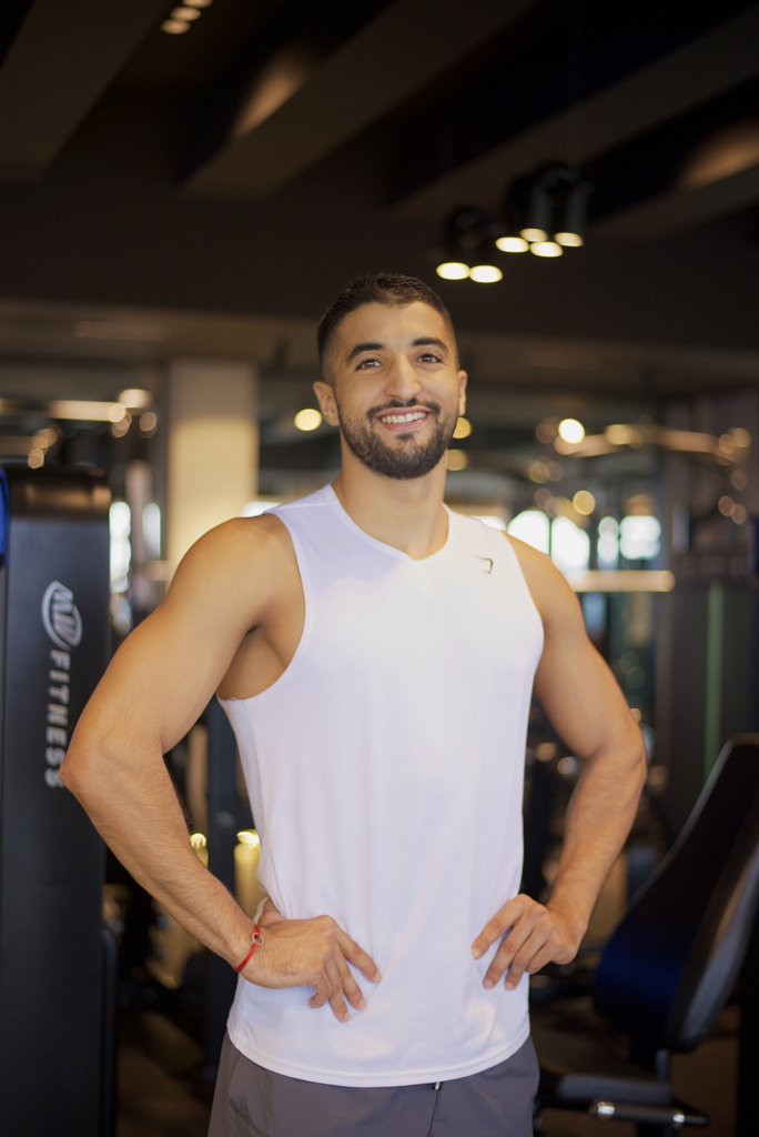 Coach Yassine Baggag souriant en Arrival Tank musculation homme