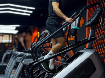 Bahae Sthetic en t-shirt noir et short sur une machine à escaliers en salle de sport
