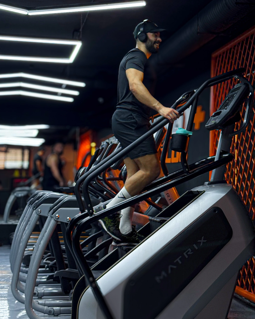 Bahae Sthetic en t-shirt noir et short sur une machine à escaliers en salle de sport