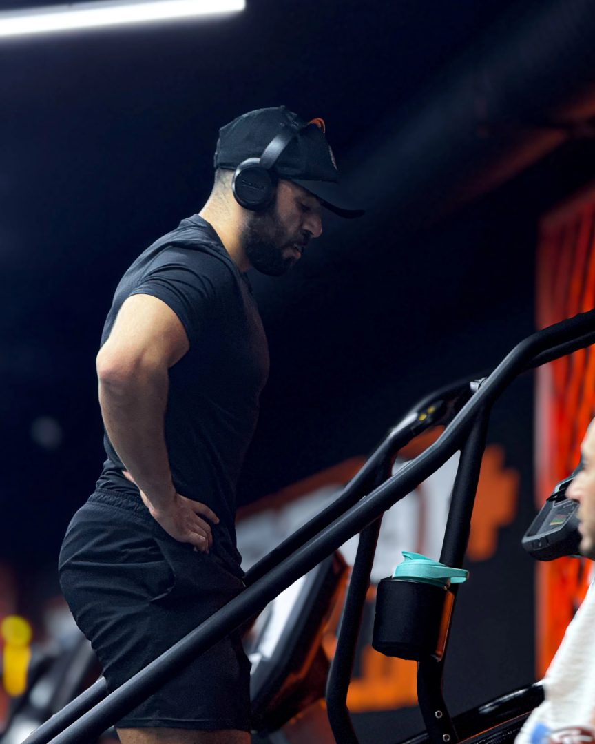 Bahae Sthetic de profil en t-shirt noir ajusté sur une machine de cardio